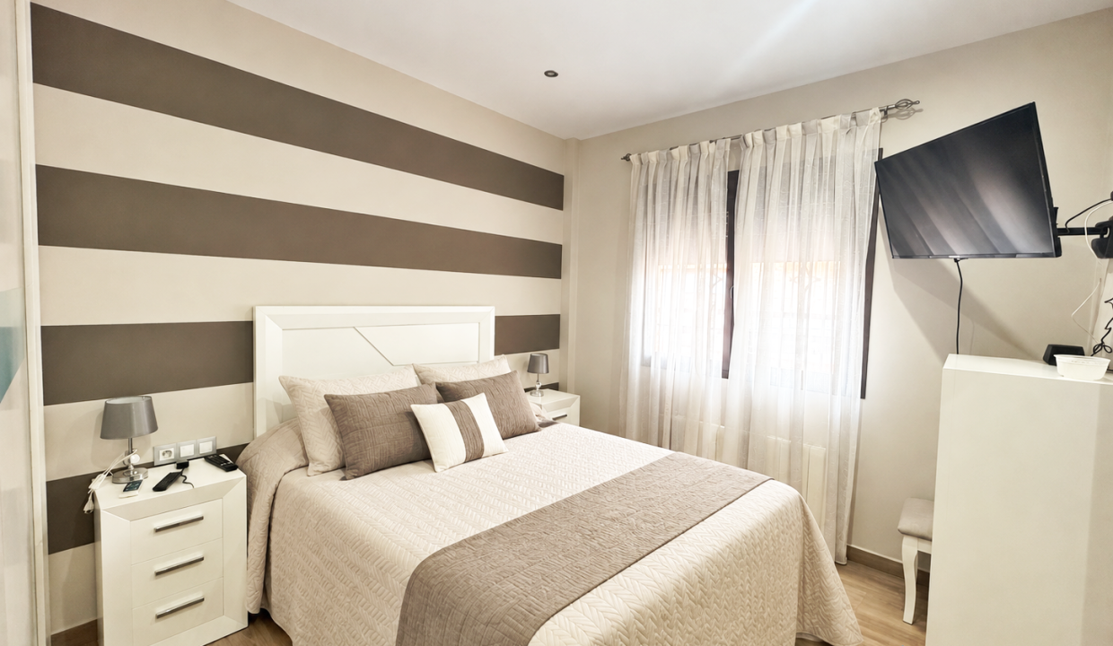 Dormitorio moderno con cama impecable y tonos neutros