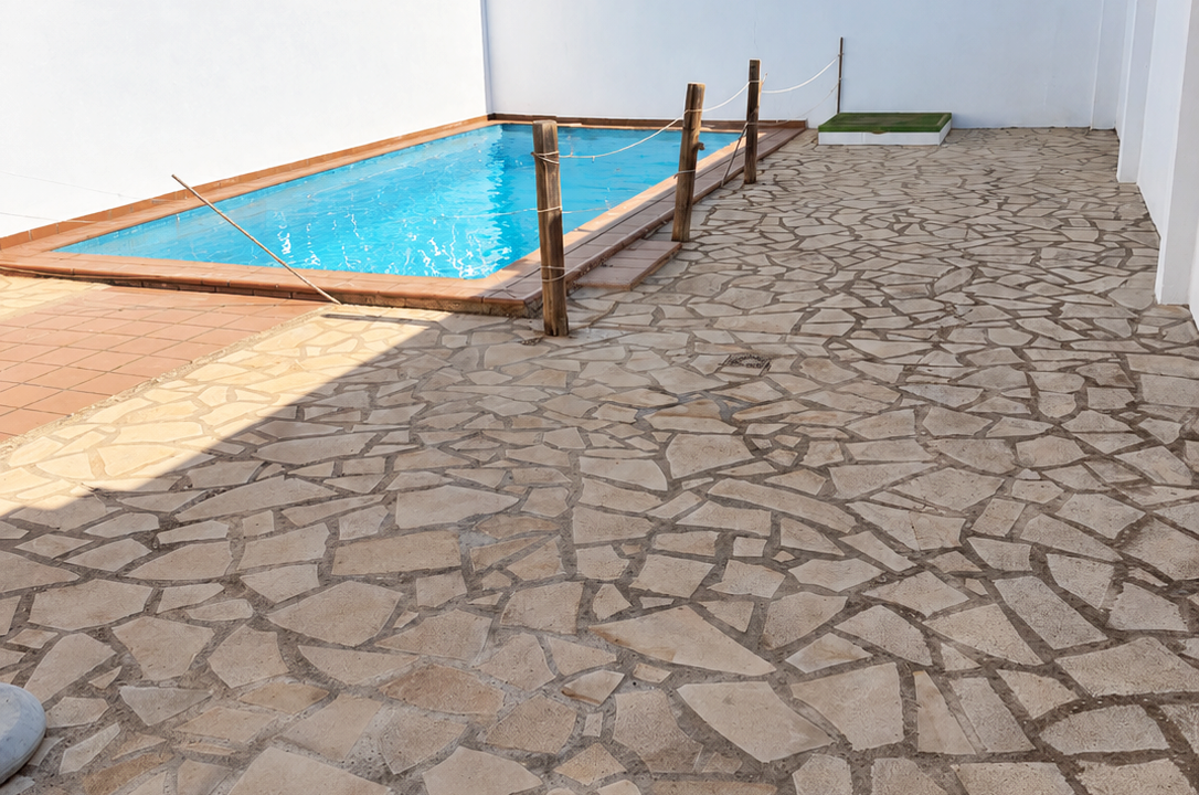 Patio mediterráneo con piscina azul