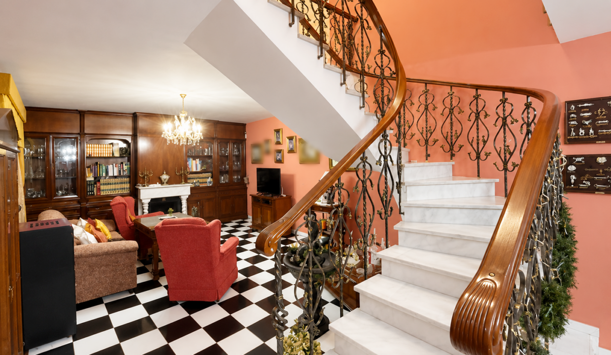 Salón clásico con escalera de mármol y lámpara de araña